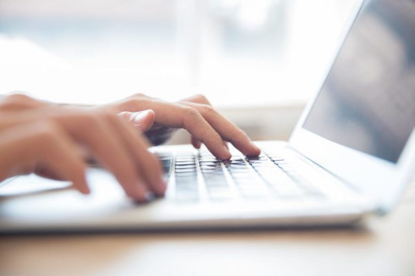 Close-up of male hands typing on laptop keyboard Close-up of male hands typing on laptop keyboard indoors. Businessman working in office or student browsing information